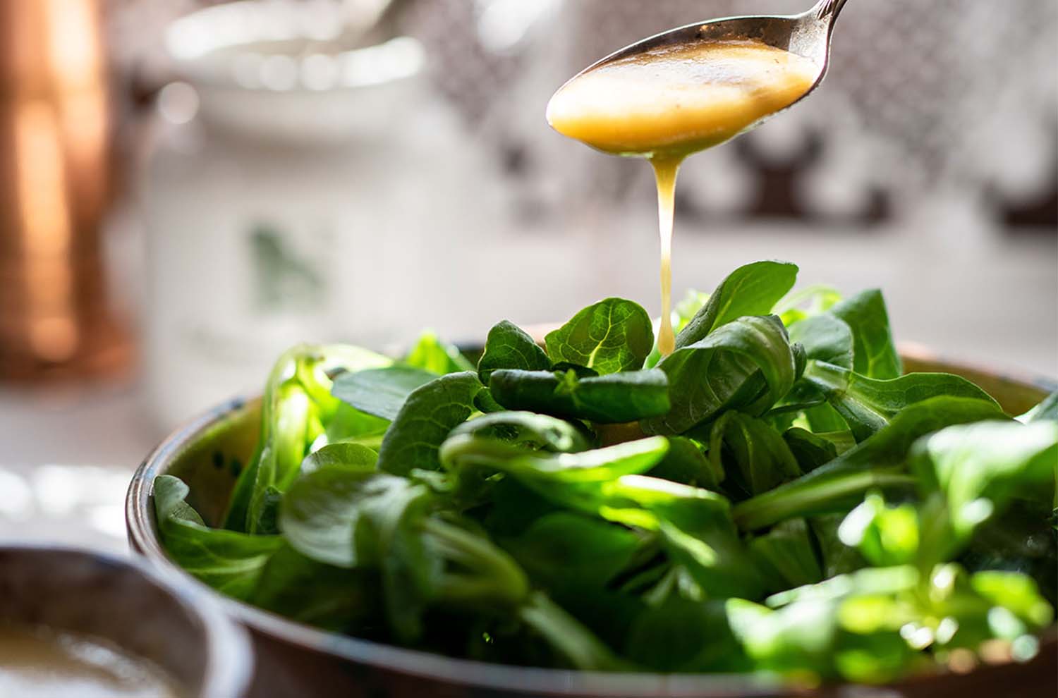 green salad with vinaigrette dressing in spoon