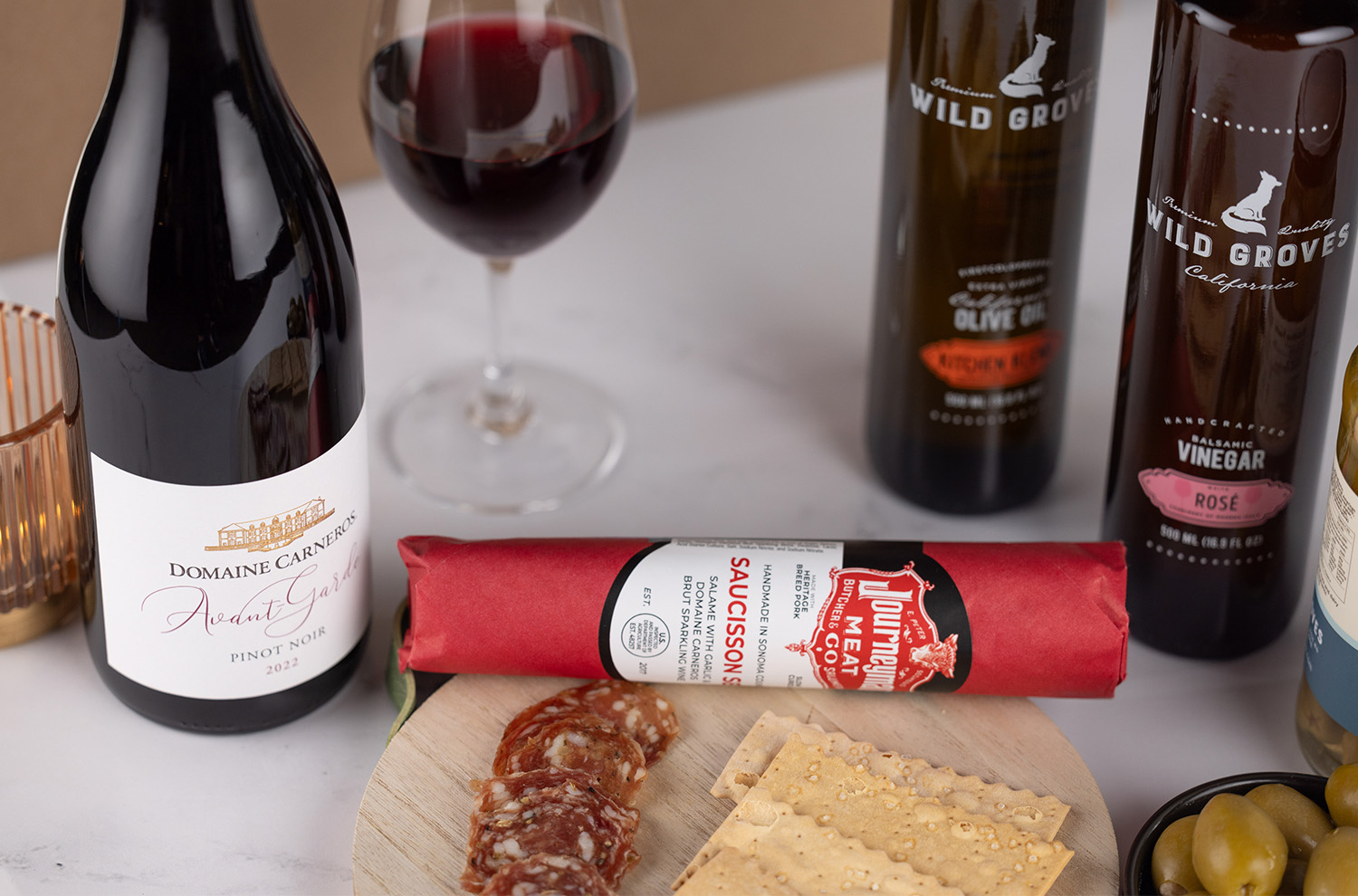 Saucisson Sec salumi with olives and bottle of Avant-Garde Pinot Noir