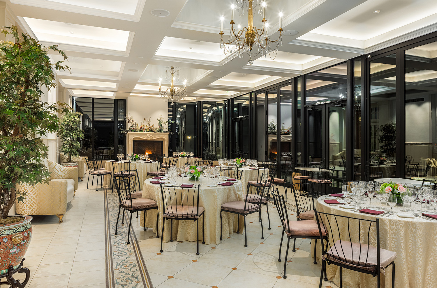 Jardin room with fireplace lit and round tables set with linens and glassware