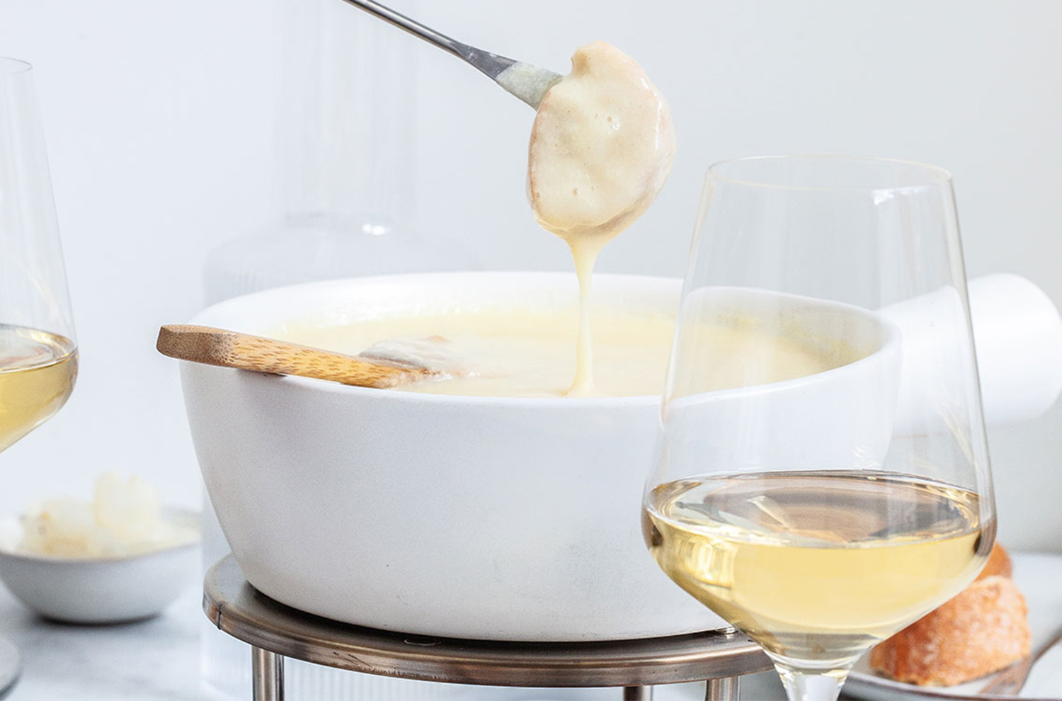 close up on fondue dip with glass of wine