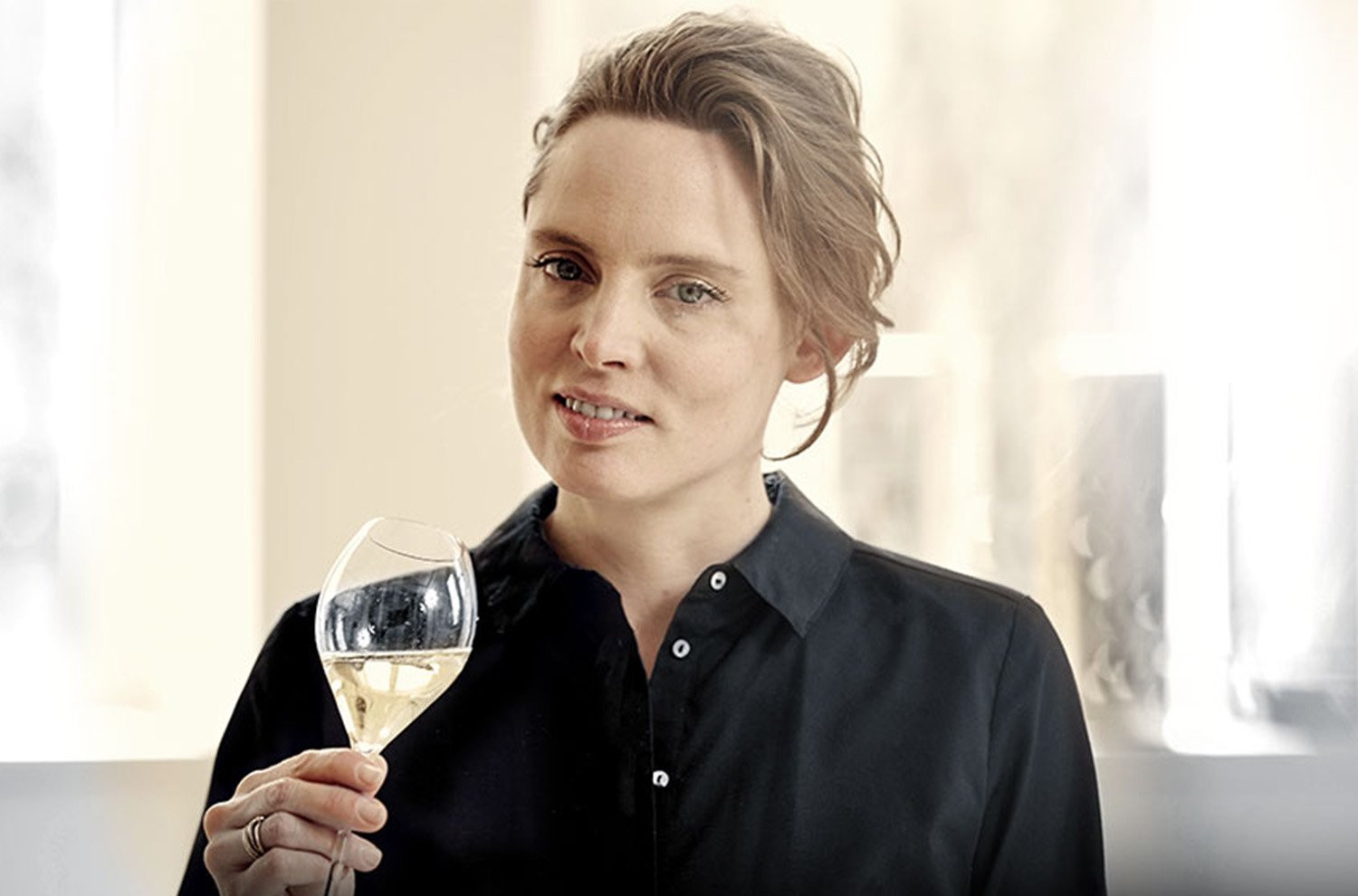 portrait of Vitalie Taittinger holding sparkling wine flute