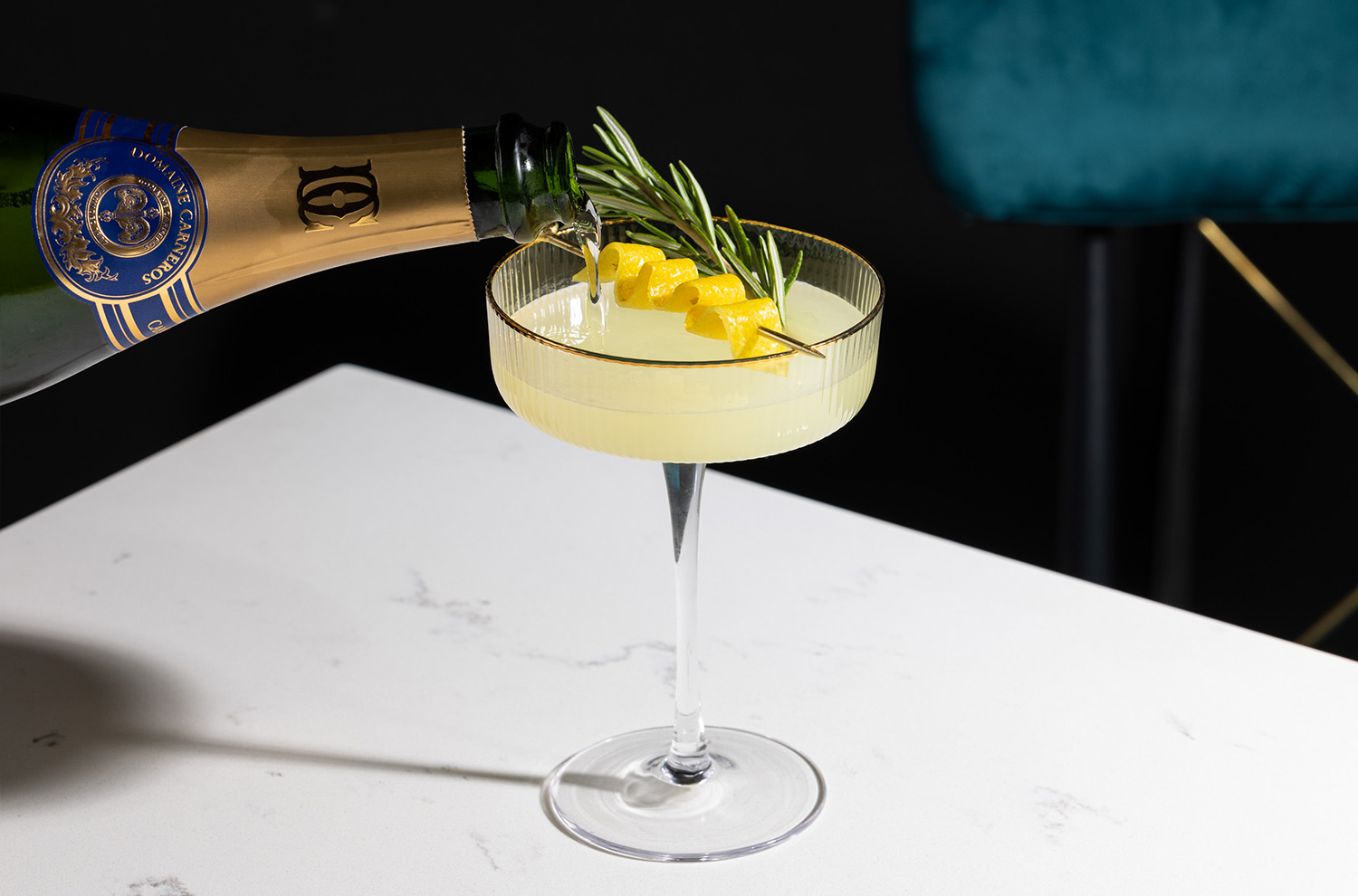 sparkling wine poured into coupe with lemon twist