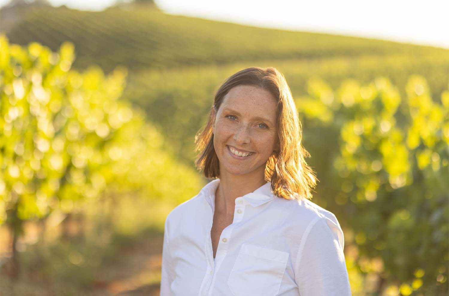 Director of Vineyards Allison standing against Carneros hill of vineyards