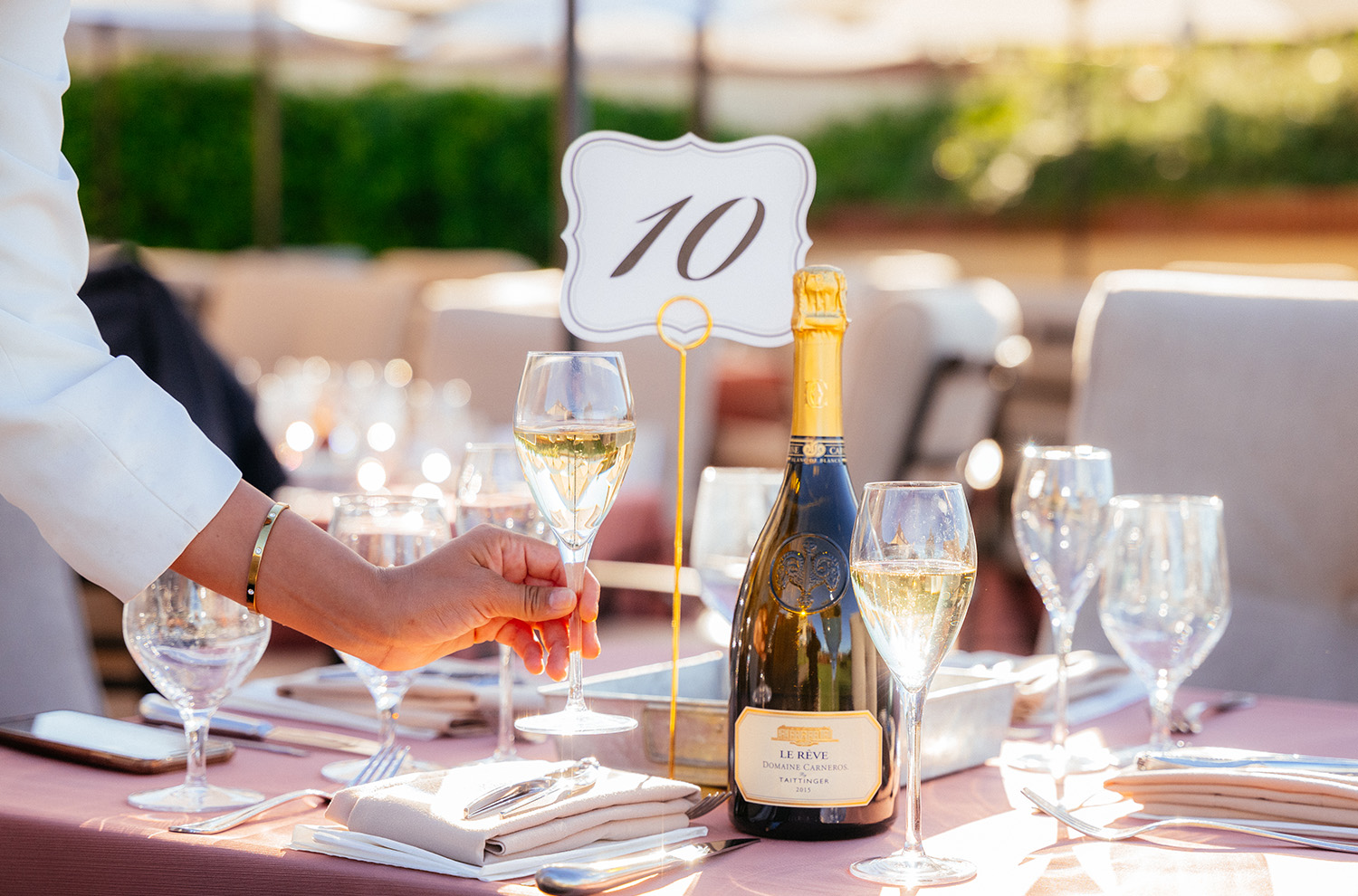 Table setting with bottle of Le Reve and glass of sparkling wine