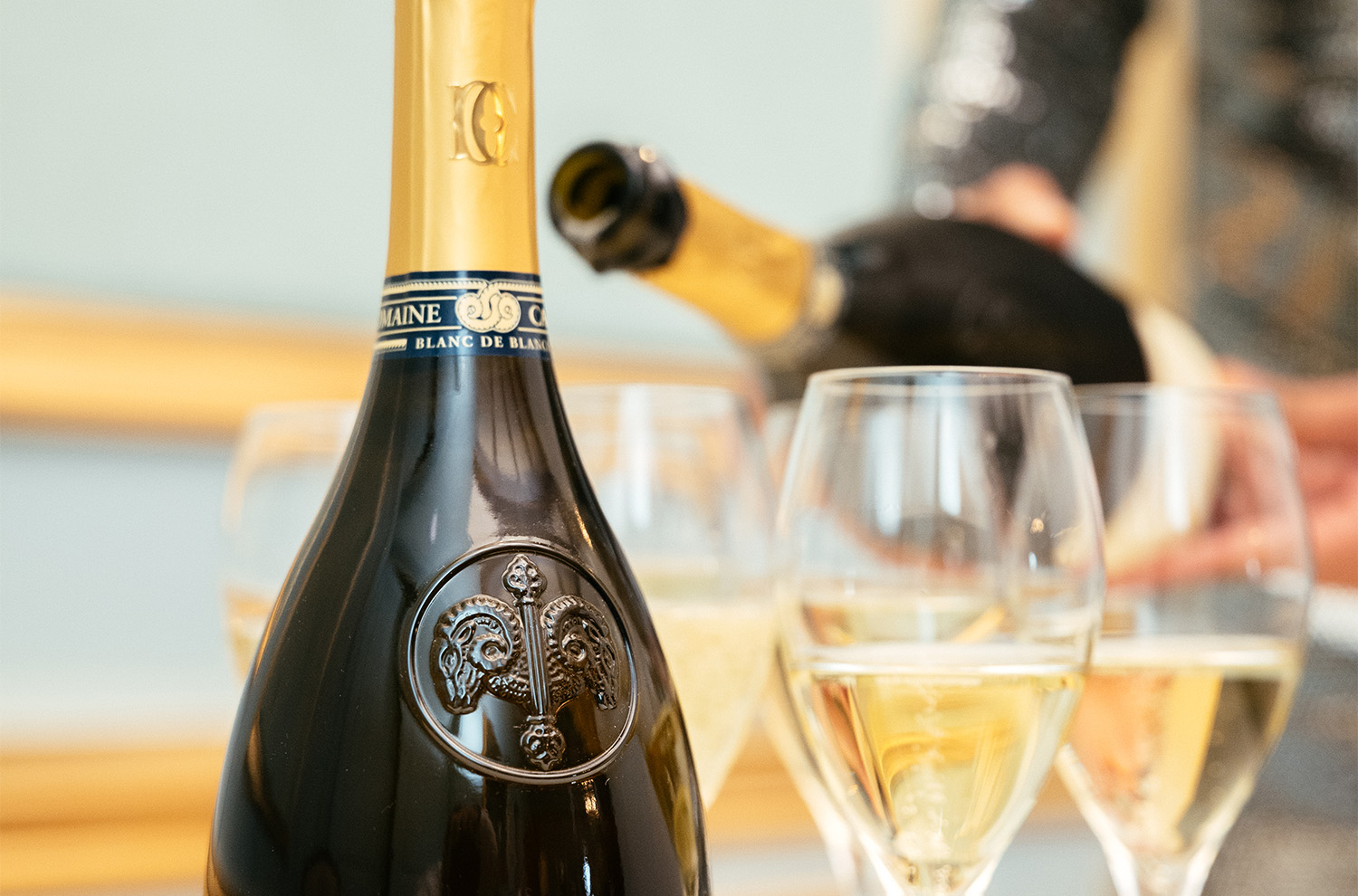 Bottle of Le Reve neckband with glasses in background