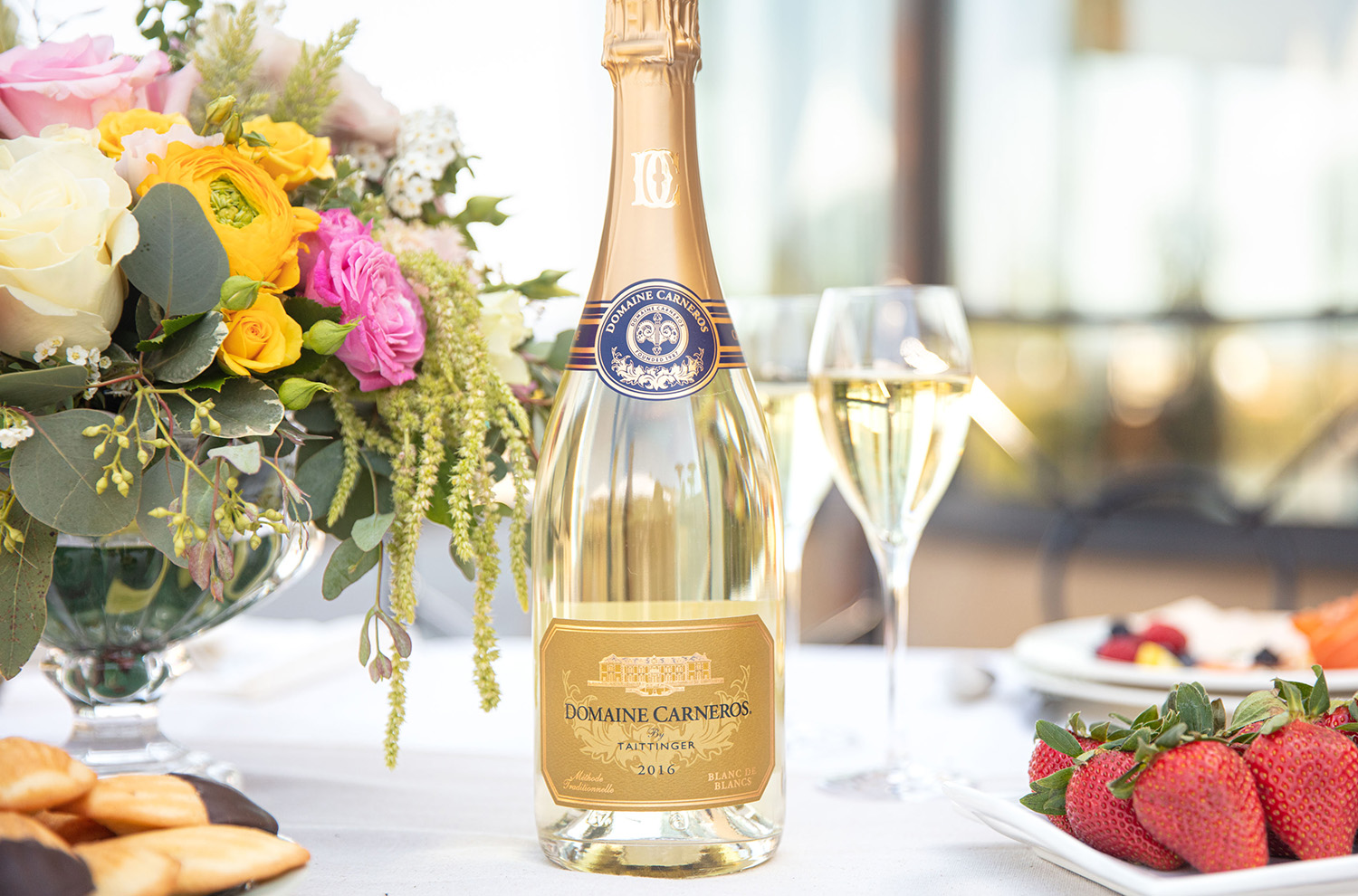 bottle of Blanc de Blancs with flower bouquet and strawberries