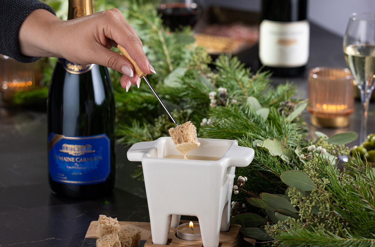 hand dipping into Fondue pot with LD Brut bottle in background