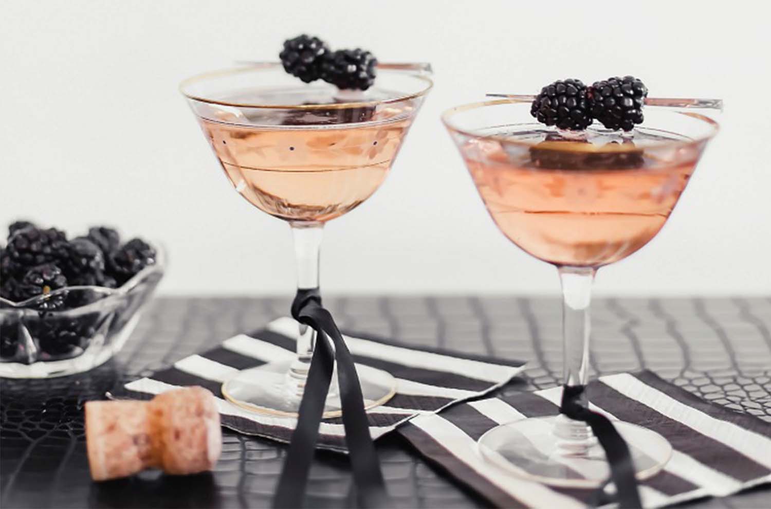 tow coupes with pink sparkling rose and blackberries