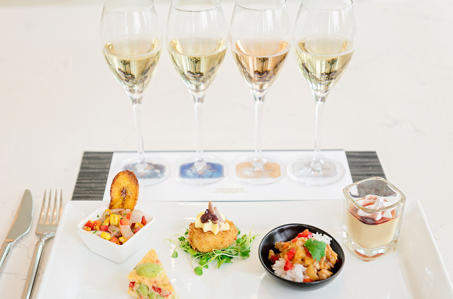 Plate of Peruvian cuisine with 4 flutes of sparkling wine