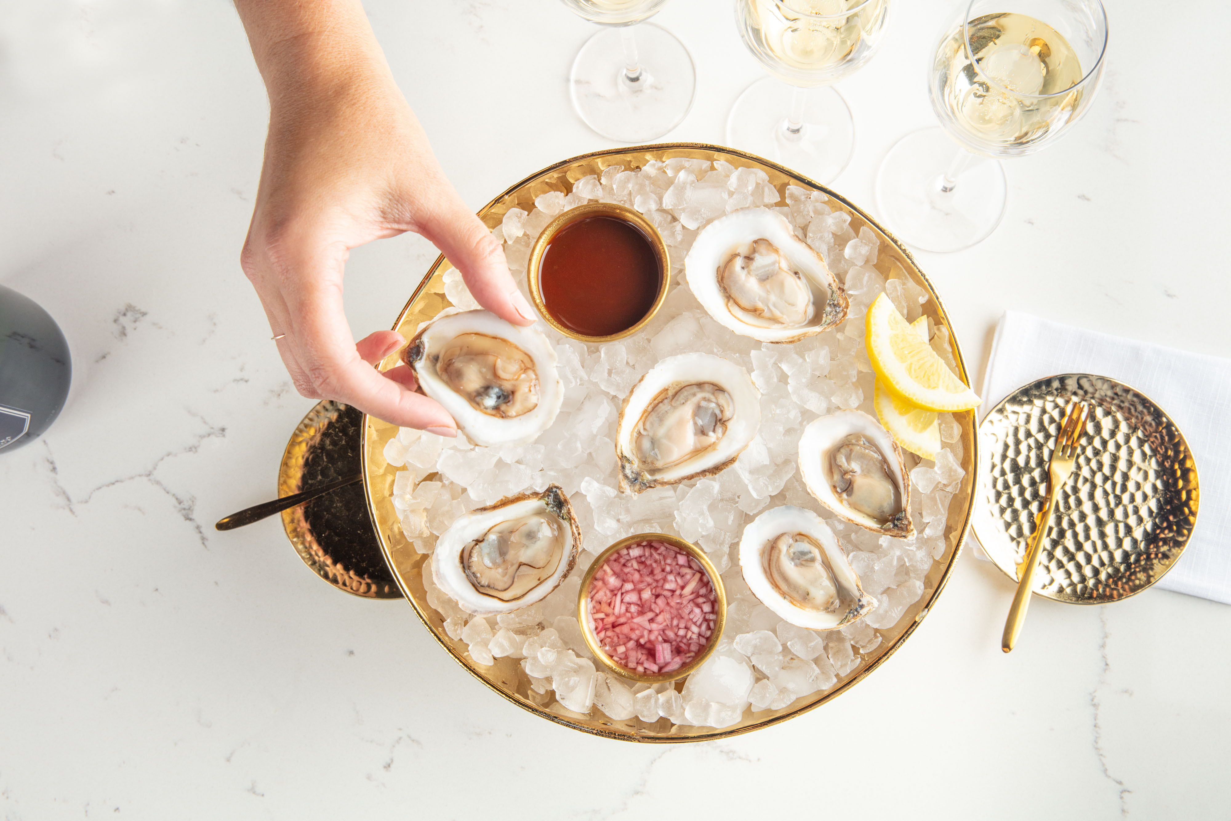 hand selecting an oyster from a bed of ice