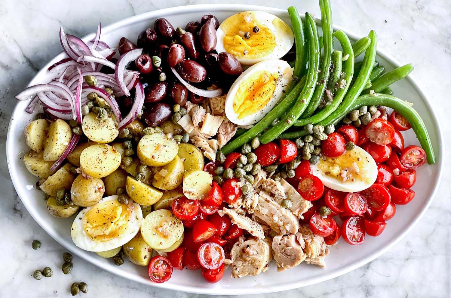 Salad Niçoise on white marble table